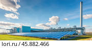 Solar panels and wind turbine powering modern industrial factory. Стоковое AI-изображение, AI-художник Юрий Поздников / Фотобанк Лори