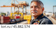 Dockworker looking away with cargo cranes and containers in background. Стоковое AI-изображение, AI-художник Юрий Поздников / Фотобанк Лори