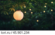 Tranquil spring evening with dim lantern light among lush greenery. Стоковое AI-изображение, AI-художник ФотоИнтеллект / Фотобанк Лори