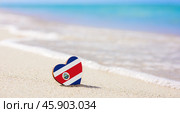 Flag of the Costa Rica in the shape of a heart on a sandy beach. The concept of the best vacation in Costa Rica. Стоковое фото, фотограф Никита Бурденков / Фотобанк Лори