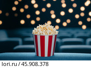 Ведро с попкорном в кинотеатре. Стоковое AI-изображение, AI-художник Башкирова Анна / Фотобанк Лори