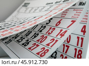 Переворачивание листов календаря с черными и красными цифрами / Flipping of calendar sheets with black and red numbers. Стоковое фото, фотограф Петроченко Мария Петровна / Фотобанк Лори