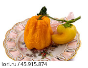 Shriveled fruits of yellow sweet pepper lie on a plate White background. There is a place for inserts. Стоковое фото, фотограф Андреева Тамара Викторовна / Фотобанк Лори