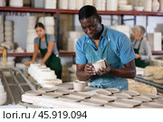 Male ceramist carving new clay plates. Стоковое фото, фотограф Яков Филимонов / Фотобанк Лори