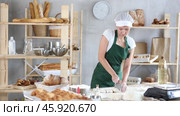 Woman is standing with cutter in her hands, working with dough, divide raw dough. Стоковое видео, видеограф Яков Филимонов / Фотобанк Лори