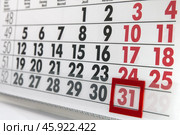 Лист календаря с чёрными и красными цифрами с красным бегунком на последнем дне месяца / Calendar sheet with black and red numbers with a red runner on the last day of the month. Стоковое фото, фотограф Петроченко Мария Петровна / Фотобанк Лори