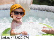 It's a hot day. A cute boy in sunglasses and a panama hat swims on a circle in a foam pool. The concept of summer holidays with children. Стоковое фото, фотограф Photojuli / Фотобанк Лори