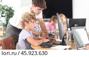 Curious underage boy engaged in IT training with help of teacher in computer courses. Стоковое видео, видеограф Яков Филимонов / Фотобанк Лори