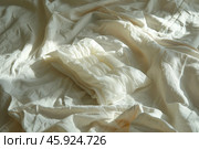 White pillow lying on unmade bed in sun. Стоковое AI-изображение, AI-художник Иван Рябоконь / Фотобанк Лори