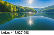 Sparkling lake reflecting lush green forest and sun. Стоковое AI-видео, аниматор Юрий Поздников / Фотобанк Лори