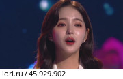 Young female performer passionately singing on illuminated stage, wearing elegant dress while expressing musical emotion during dynamic concert performance. Стоковое видео, видеограф Данил Руденко / Фотобанк Лори