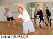 Mature women warming-up before their group fitness training. Стоковое фото, фотограф Яков Филимонов / Фотобанк Лори