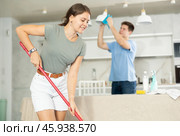 Positive girl and her husband are cleaning kitchen. Стоковое фото, фотограф Яков Филимонов / Фотобанк Лори