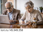 Pension. Saving money. Savings. An elderly couple calculates their savings. Financial literacy. Стоковое AI-изображение, AI-художник Photojuli / Фотобанк Лори