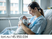 A woman in a hospital bed in the maternity ward. Mom has a newborn baby in her arms. Pregnancy and childbirth. Стоковое AI-изображение, AI-художник Photojuli / Фотобанк Лори