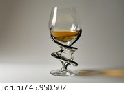 Elegant glass with liquor and twisted stem on white background. Стоковое AI-изображение, AI-художник Иван Рябоконь / Фотобанк Лори