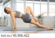 Young woman practicing vinyasa yoga in studio. Стоковое фото, фотограф Яков Филимонов / Фотобанк Лори