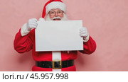 Cheerful Santa Claus Holding a Blank Sign Mock Up with Space for Your Text, Holiday Promotions and Events. Jolly Santa Claus gesturing pointing on white banner placard, festive themes advertising. Стоковое AI-видео, аниматор Марина Демидюк / Фотобанк Лори