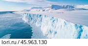 Tourists walking on snowy glacier near ocean in antarctica. Стоковое AI-изображение, AI-художник Юрий Поздников / Фотобанк Лори
