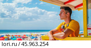 Lifeguard watching over crowded beach on sunny summer day. Стоковое AI-изображение, AI-художник Юрий Поздников / Фотобанк Лори