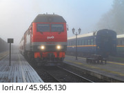 Российский пассажирский тепловоз ТЭП-70БС с  поездом Москва-Петрозаводск туманным октябрьским утром. Станция Сортавала, Карелия. Редакционное фото, фотограф Виктор Карасев / Фотобанк Лори