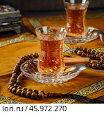 Azerbaijani black tea in armudu tea glass. Atmosphere of Baku and Eastern traditions. Oriental cuisine. Cozy atmosphere in the caucasus cafe. Стоковое фото, фотограф Андрис Салминьш / Фотобанк Лори