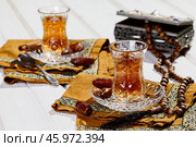 Azerbaijani black tea in armudu tea glass. Atmosphere of Baku and Eastern traditions. Oriental cuisine. Cozy atmosphere in the caucasus cafe. Стоковое фото, фотограф Андрис Салминьш / Фотобанк Лори