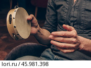 Man play tambourine, musician timbrel performs at concert in nightclub bar. Стоковое фото, фотограф Spirit River / Фотобанк Лори