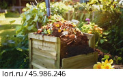 Organic waste, including leaves and grass clippings, is added into a compost pit, promoting eco-friendly recycling and composting of biodegradable materials. Стоковое AI-видео, аниматор ALLA YURTAYEVA / Фотобанк Лори
