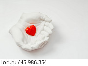 Stylish banner. In his hands, a red heart on a white background is made of plaster. World Health, Love and Insurance Day. World Heart, Health and Organ Donor Day. Стоковое фото, фотограф Photojuli / Фотобанк Лори