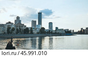 Yekaterinburg, Russia - August 5, 2021: Yekaterinburg skyline mirroring on iset river during twilight, modern architecture blending with waterfront tranquility and urban evening atmosphere. Редакционное фото, фотограф Mikhail Davidovich / Фотобанк Лори