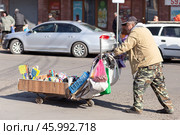 Блошиный рынок Самгори в Тбилиси, Грузия. Продавец со своим товаром в тележке. Редакционное фото, фотограф Evgenia Shevardina / Фотобанк Лори