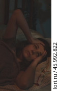 Vertical video. Woman suffering from insomnia and headache lying in bed at night. Стоковое видео, видеограф Маргарита Кирьякова / Фотобанк Лори