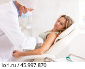 Female patient receiving intramuscular injection from doctor in medical office. Стоковое фото, фотограф Яков Филимонов / Фотобанк Лори