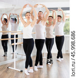 Female ballet dancer executing fifth position during group rehearsal. Стоковое фото, фотограф Яков Филимонов / Фотобанк Лори