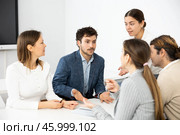 Emotional language teacher telling interesting stories to adult attentive students during class break in auditory. Стоковое фото, фотограф Яков Филимонов / Фотобанк Лори