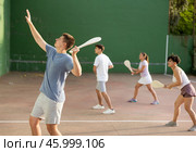 Concentrated young man paleta fronton player hitting ball with racket. Стоковое фото, фотограф Яков Филимонов / Фотобанк Лори