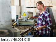 Confident woman machine operator working with automatic conveyor filling and seeding of plants in greenhouse. Стоковое фото, фотограф Яков Филимонов / Фотобанк Лори