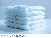 Stack of adult diapers wrapped in rubber band on table. Стоковое AI-изображение, AI-художник Иван Рябоконь / Фотобанк Лори