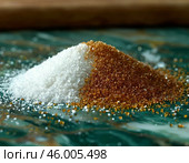 Scattered white and brown granulated sugar on wooden kitchen table. Стоковое AI-изображение, AI-художник Сергей Елизарьев / Фотобанк Лори