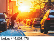 Яркий утренний рассвет оранжевого цвета, дворник убирает от снега улицу зимой. Street photo. Стоковое AI-изображение, AI-художник Сергей Никифоров-Гордеев / Фотобанк Лори