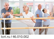Male choreographer teaches elderly ballet lovers to stand in grand batman position. Стоковое фото, фотограф Яков Филимонов / Фотобанк Лори