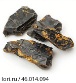 Black tourmaline crystals showing golden pyrite inclusions on white background. Стоковое AI-изображение, AI-художник Иван Рябоконь / Фотобанк Лори