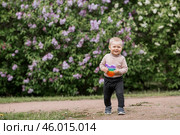 A beautiful chubby 2-year-old child in the park with a colorful Pop-it game. An anti-stress remedy. A pop It toy in children's hands. Стоковое фото, фотограф Photojuli / Фотобанк Лори
