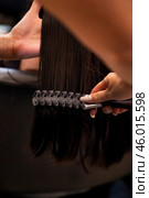 Barber shop, close-up hands of hairstylist combing hair with comb for brunette lady in hair salon. Hairdresser make beauty hairdo, barber spa. Customer service, hair salon concept. Copy ad text space. Стоковое фото, фотограф Aleksandr Golubev / Фотобанк Лори