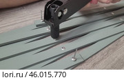 DIY Pulling out rivets hand tool. Making a wooden lattice pergola support for a rose garden. The diamond lattice is sliding. Sage color, elements of an English garden with your own hands. Стоковое видео, видеограф Елизавета Малкова / Фотобанк Лори