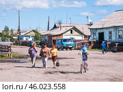 Сельская местность, дома, улица, женщины, дети. Поселок Томтор в Якутии ( Республика САХА, Оймяконский район ). Это очень удаленное место от Большой Земли, и жизнь здесь течет неторопливо (2010 год). Редакционное фото, фотограф Павел Просянов / Фотобанк Лори