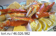 Red king crab legs with fresh lemon slices. Delicious seafood and luxury restaurant menu. Стоковое видео, видеограф Андрей Армягов / Фотобанк Лори