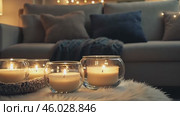 Candles and Soft Textile. Cozy Living Room Details. Flickering burning candle glasses, plush knit blanket. Atmosphere of serenity and comfort. Gray and brown color scheme. Modern boho house interior. Стоковое AI-видео, аниматор Марина Демидюк / Фотобанк Лори
