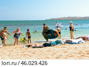 A young woman on the seashore is preparing to swim on a supboard (2024 год). Редакционное фото, фотограф Алексей Сорокин / Фотобанк Лори